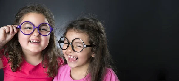 Маленькие сестрички и очки — стоковое фото