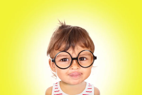 Kleines Mädchen mit schwarzer Brille blickt in die Kamera — Stockfoto