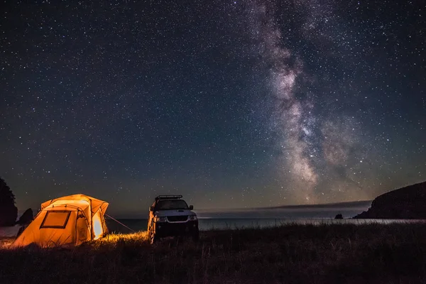 Tourist camping at sea coast at night with milky way — Stock Photo, Image