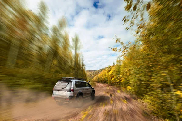 SUV in movimento veloce su strada sterrata nella foresta — Foto Stock