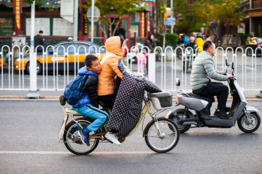 Pekin, Çin - 11 Kasım 2019: Pekin 'de bisiklet süren bir kadın