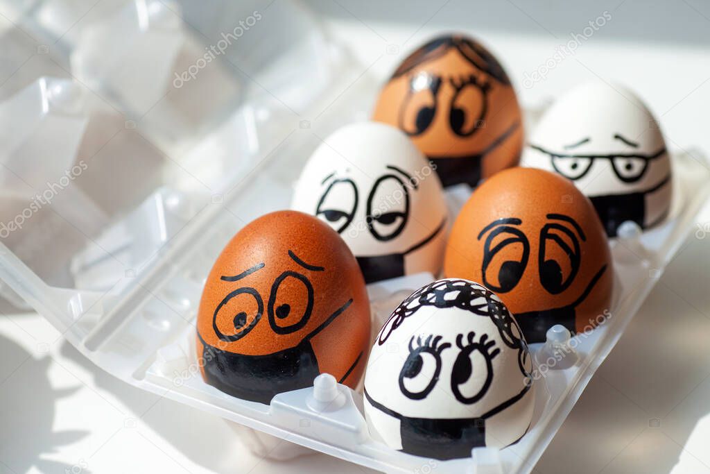 Eggs with different painted faces and medical masks