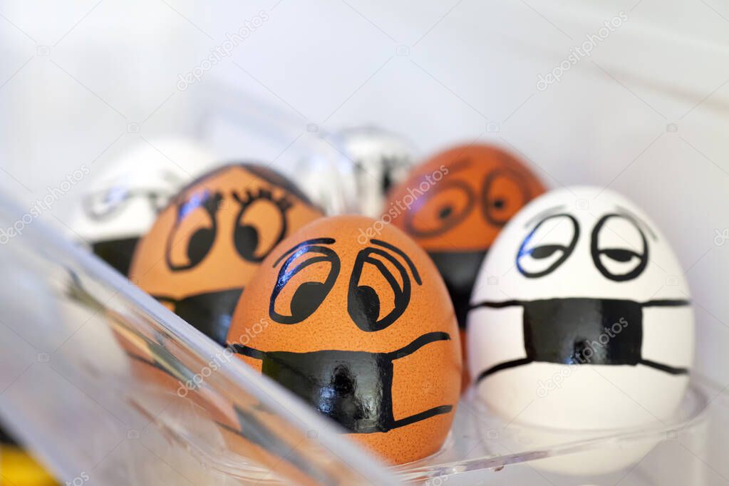 Eggs with different painted faces and medical masks