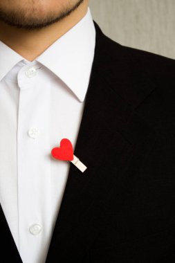 Kırmızı kalpli siyah elbiseli adam