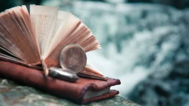 Eski kitap, saat arka planda bir şelale