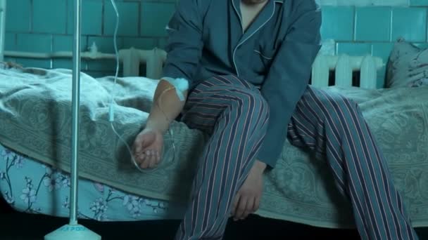 De patiënt zit op het bed op een vrij verkeer van infuus — Stockvideo