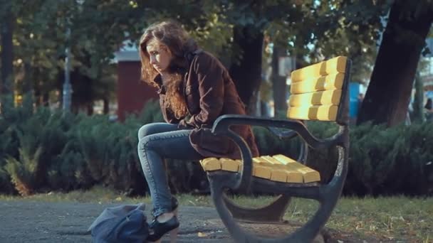 Triste fille sur un banc dans le parc — Video