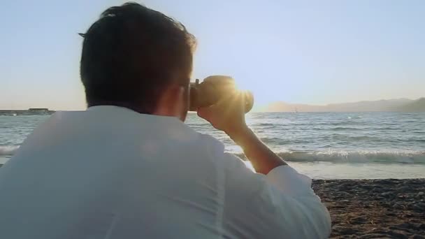 Adam dürbün ile sahilde — Stok video