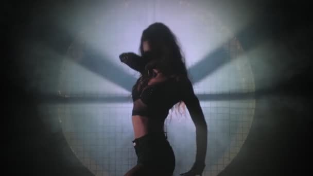 Ung kvinna dansar i ett mörkt rum — Stockvideo