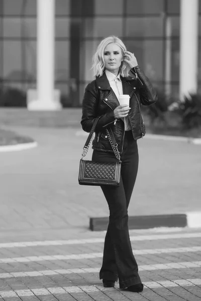 Mode mooi in trendy kleding vrouw Kruis de weg en lopen op straat met een kopje koffie — Stockfoto