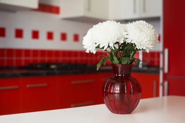 Bouquet on a table of red and white kitchen interior