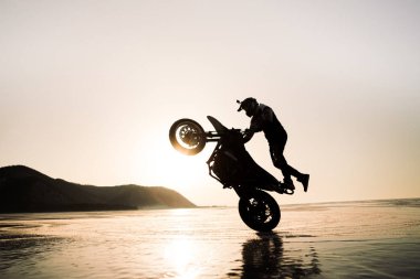 Motosikletle buz üstünde oynayan adam.