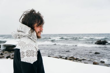 Kışın Baykal Gölü yakınlarında siyah kıvırcık saçlı bir adam.