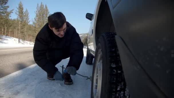 Chlap Měnící Auto Kolo Silnici Slunečný Zimní Den Sibiři — Stock video