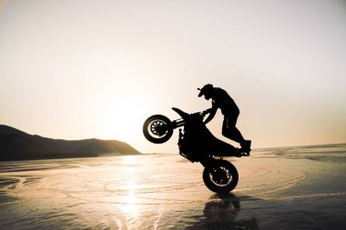 stunt rider ridin on a back wheel of motorcycle