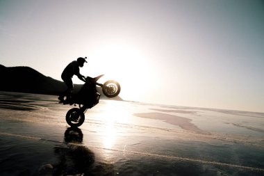 stunt rider ridin on a back wheel of motorcycle