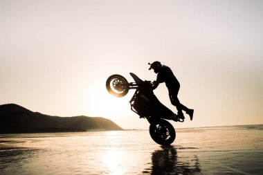 stunt rider ridin on a back wheel of motorcycle