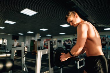 Spor salonunda halter hazırlayan bir adam.