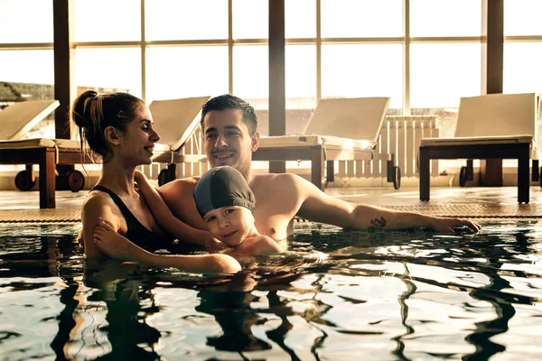 family on a vacation in an indoor swimming pool in the sunset