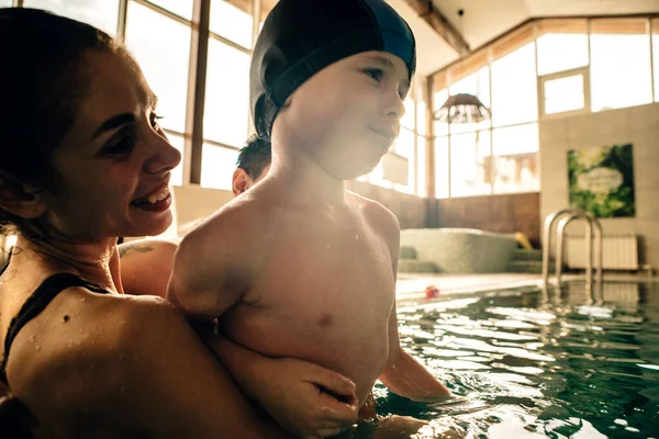 family on a vacation in an indoor swimming pool in the sunset