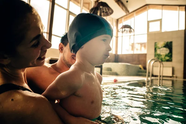 family on a vacation in an indoor swimming pool in the sunset