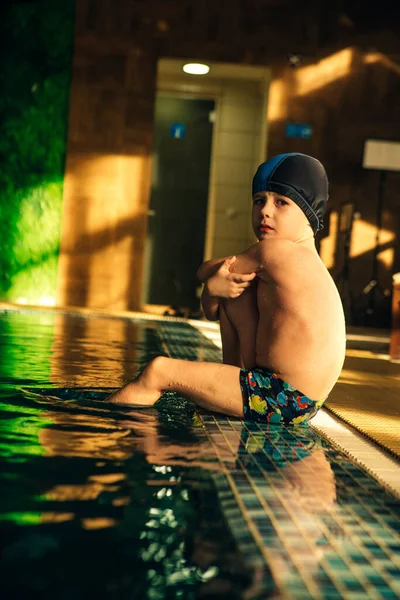 Smutné Mužské Dítě Sedící Boku Vnitřního Bazénu Západu Slunce — Stock fotografie