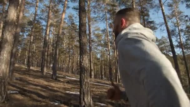 夕日の松林を走るハンサムな髭の男 — ストック動画