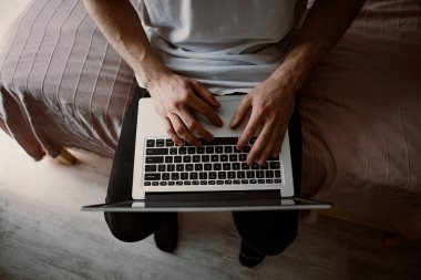 Bir erkeğin dizüstü bilgisayarda yazarken ki görüntüsü