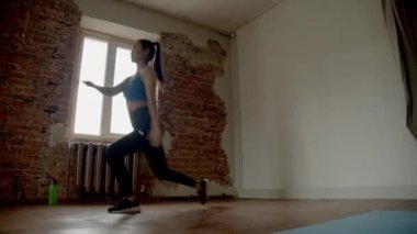 Asyalı kız bir odada bacak egzersizi yapıyor.