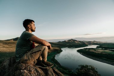 Orta Doğulu bir adam uçurumun kenarında meditasyon yapıyor.