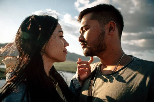 Gün batımında vadide uçurumun kenarında ırklar arası bir çift. 