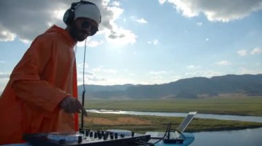Sakallı DJ dışarıda müzik çalıyor.