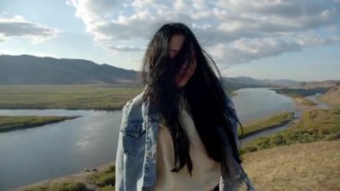 Esmer kız gün batımında dışarıda dans ediyor.