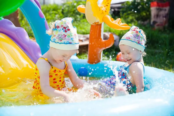 双子の女の子がプールで泳いで ロイヤリティフリーのストック写真