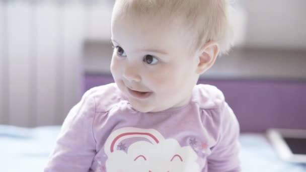 かわいい小さな女の赤ちゃんがカメラに探してと拍手. — ストック動画