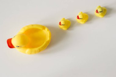 Bath toy row of yellow ducks on white background clipart