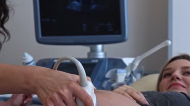 Doktor ultrason kullanýlýyor hamile kadının karın bölgesinde.