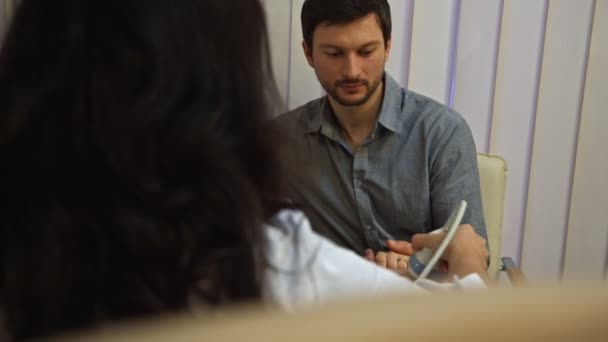 Pareja mirando la ecografía del bebé en la tableta PC en el sofá — Vídeos de Stock