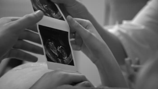 Gravid kvinna med ett sonogram skanna i office på sjukhuset — Stockvideo