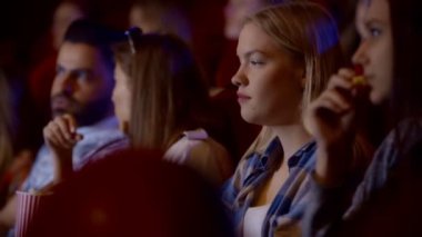 Grup tiyatro patlamış mısır ve içecekler ile insan. Genç arkadaşlar sinema film izlemek.