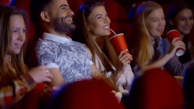 Genç kızlar ve sinemada otururken, bir film izliyorum ve içme çocuklar, arkadaşlık ve eğlence kavramının gülümseyen