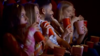 Grup arkadaşıyla birlikte bir film izlerken ve patlamış mısır, eğlence ve zevk kavramı yeme sinemada