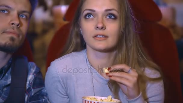 Jovem casal multicultural feliz comendo pipocas e assistindo filmes juntos no cinema — Vídeo de Stock