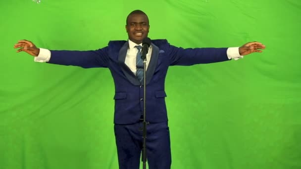 Bellissimo uomo africano che canta su sfondo verde e guarda la fotocamera . — Video Stock