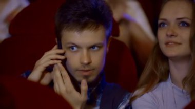 Sinema salonunda telefonda konuşan genç adam