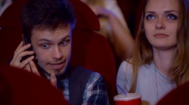 Sinema salonunda telefonda konuşan genç adam
