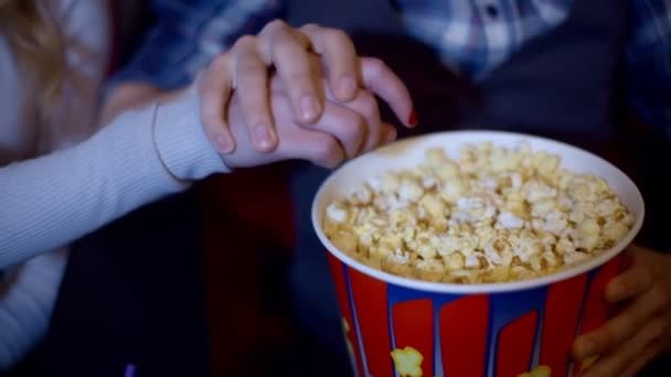 Popcorn close-up shot van een gelukkig lachende vrouw popcorn van haar vriend grijpen bijgesneden — Stockvideo