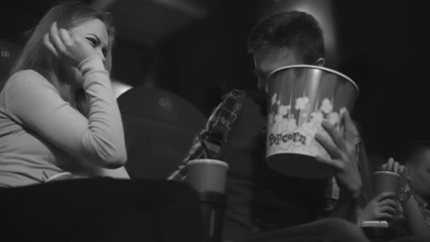 Vicces fiú és lány pihenni a mozi és a táplálkozási popkorn — Stock videók