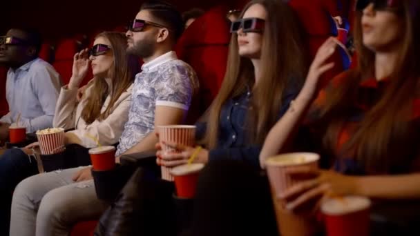 Moziban nézni egy lenyűgöző film 3D-s szemüveg, inni cola és pattogatott kukoricát eszik meg.