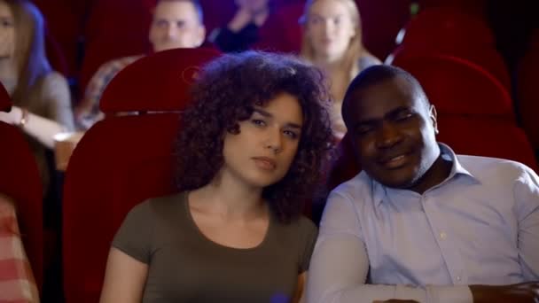 Africano chico con su novia viendo divertido película en el cine . — Vídeos de Stock